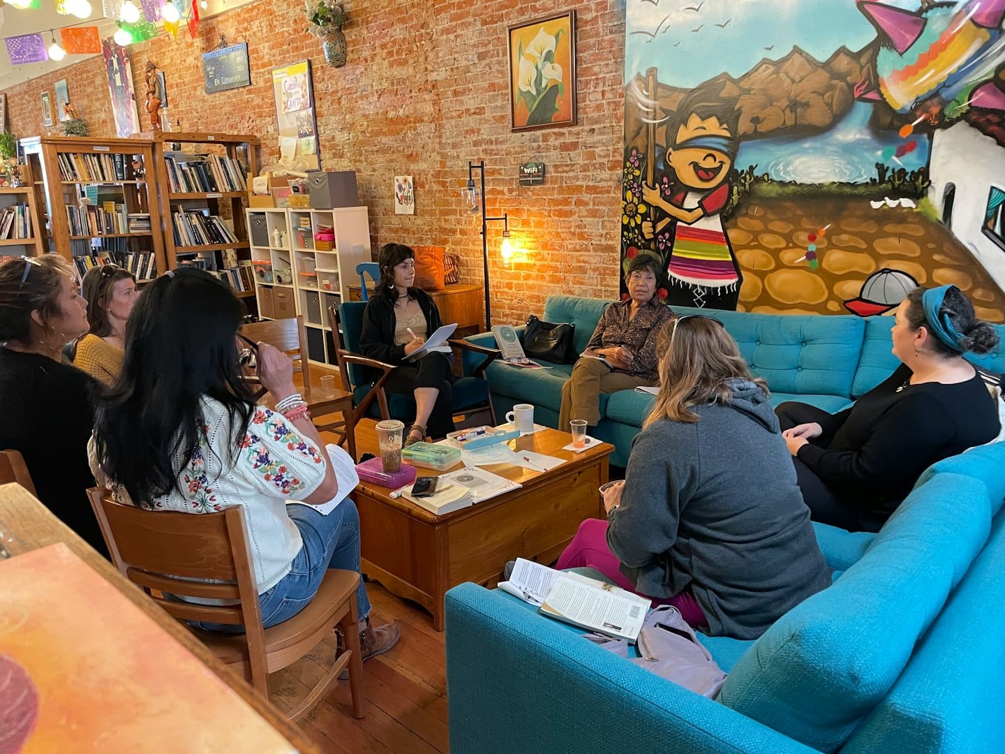 Frauen bei einem kooperativen Meeting in einem Buchladen-Café.